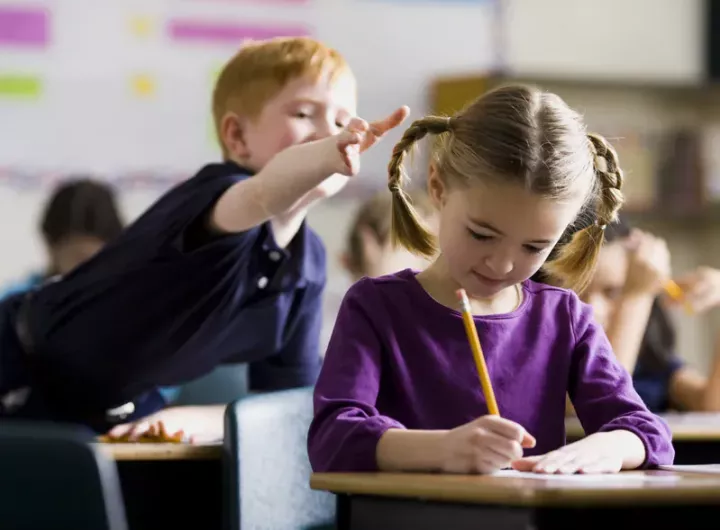 boy about to pull girl's hair in the classroom