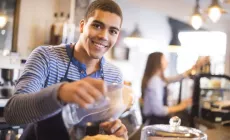 teenage boy working behind counter in a coffee shop