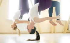 two young women hanging from yoga hammocks