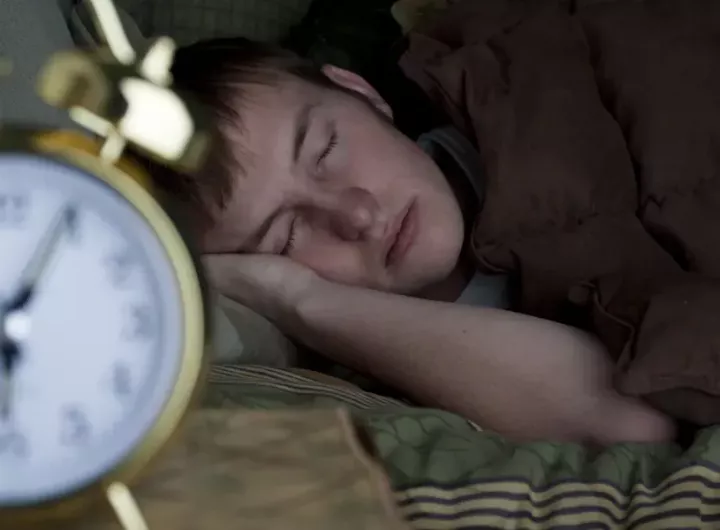 Teen_boy_snoozing_with_alarm_clock_iStock_8820264_LARGE.webp